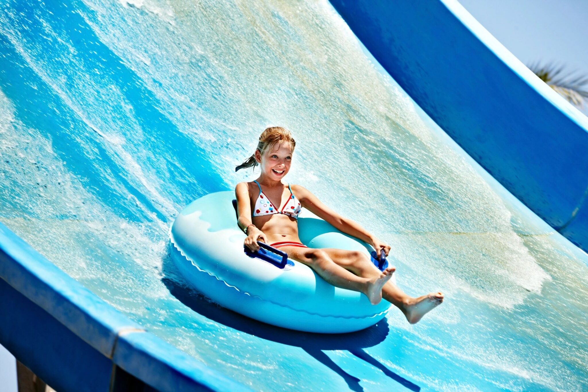 Customized Family Vacation Experiences Child enjoying a water slide during a family vacation